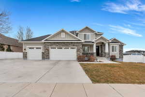 Craftsman house featuring stone siding, board and batten siding, and concrete driveway