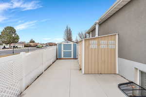 View of patio with a storage shed and a residential view
