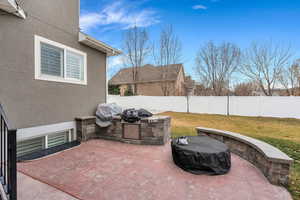 Fenced backyard featuring a patio and an outdoor kitchen