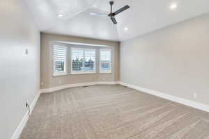 Unfurnished room featuring light carpet, ceiling fan, vaulted ceiling, and recessed lighting