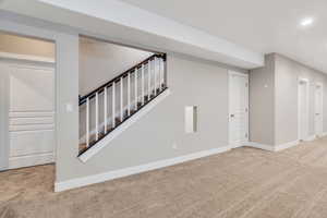 Finished below grade area featuring light carpet and recessed lighting