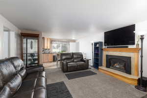 Living area featuring light colored carpet and a fireplace