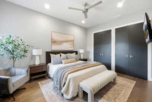 Bedroom featuring two closets, wood-type flooring, recessed lighting, and a ceiling fan