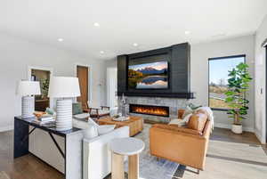 Living area featuring wood finished floors, a fireplace, and recessed lighting