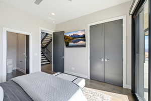Bedroom with a closet, a ceiling fan, wood finished floors, connected bathroom, and recessed lighting