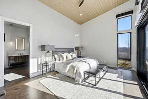 Bedroom with wood-type flooring, ensuite bathroom, a vaulted wooden ceiling, and recessed lighting
