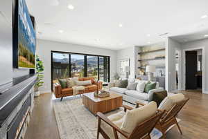 Living room featuring light wood finished floors, bar, recessed lighting, and a fireplace
