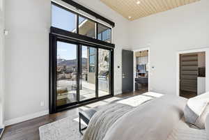 Bedroom with a mountain view, hardwood / wood-style floors, a spacious closet, access to outside, and recessed lighting