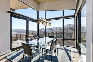 Sunroom featuring a mountain view, hanging lights, and plenty of natural light