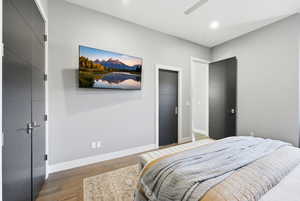 Bedroom with light wood finished floors, ceiling fan, and recessed lighting