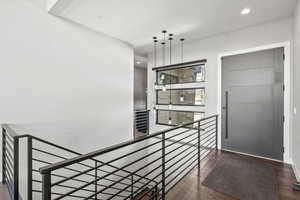 Stairs featuring wood finished floors and recessed lighting
