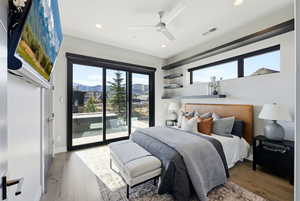 Bedroom with a ceiling fan, wood finished floors, access to exterior, and recessed lighting