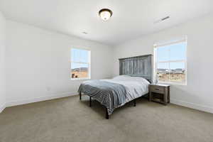 Bedroom featuring light carpet