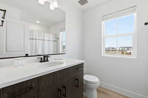 Full bathroom with vanity, curtained shower, and light wood-style floors