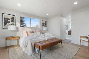 Bedroom with light wood-style floors, recessed lighting, and ensuite bath