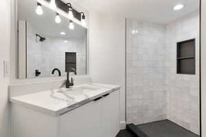 Full bathroom featuring vanity, recessed lighting, and a tile shower