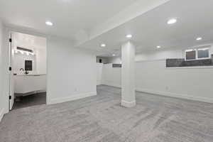 Below grade area with light carpet and recessed lighting