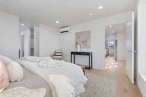 Bedroom featuring recessed lighting, light wood finished floors, and freestanding refrigerator