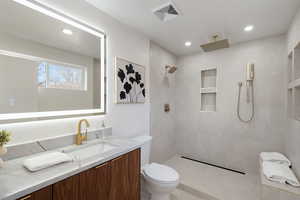 Full bath with vanity, a tile shower, and recessed lighting