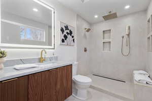 Full bathroom with vanity, a tile shower, and recessed lighting