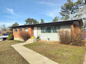 Ranch-style house with brick siding and a front lawn