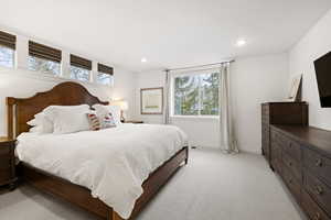 Bedroom with light colored carpet and recessed lighting