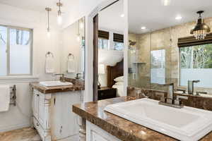 Bathroom featuring healthy amount of natural light, vanity, a tile shower, and ensuite bathroom
