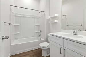 Full bathroom featuring vanity, shower / bath combination, and dark wood-type flooring