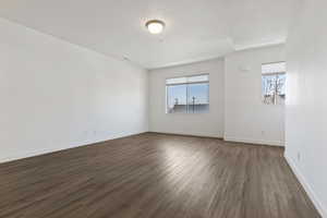 Unfurnished room with dark wood-type flooring and baseboards