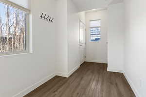 Doorway to outside featuring baseboards and wood finished floors
