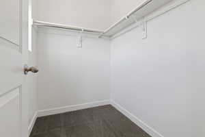 Walk in closet with dark carpet