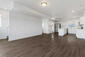 Unfurnished living room featuring recessed lighting and dark wood-type flooring