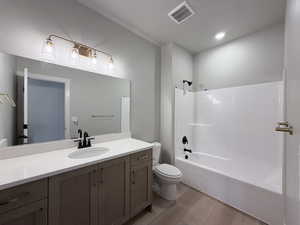 Full bathroom with vanity, shower / washtub combination, light wood finished floors, and recessed lighting