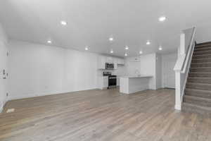 Unfurnished living room featuring light wood-style flooring and recessed lighting