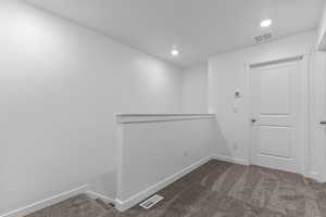 Spare room featuring dark carpet and recessed lighting