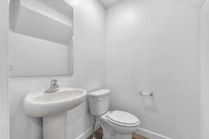 Bathroom with lofted ceiling and wood finished floors