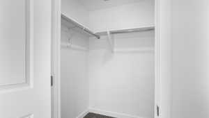 Walk in closet with dark colored carpet