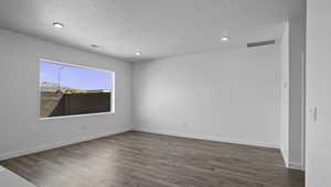 Spare room with light wood-style floors, a textured ceiling, and recessed lighting