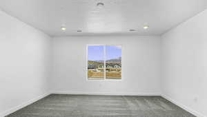 Spare room featuring light colored carpet and a mountain view