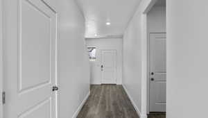 Corridor with dark wood finished floors and recessed lighting