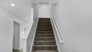 Stairs with recessed lighting and wood finished floors