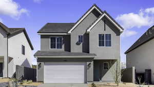 Traditional home with an attached garage, driveway, a tiled roof, and stucco siding