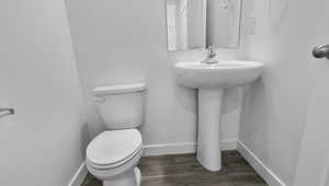 Bathroom with toilet and wood finished floors
