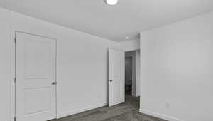 Unfurnished bedroom with carpet and baseboards