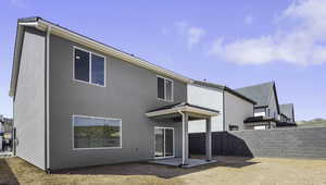 Back of house with a patio area and stucco siding
