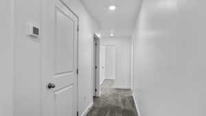 Hallway with carpet floors and recessed lighting