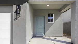 Entrance to property featuring stucco siding and a patio area