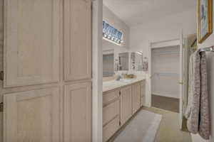 Full bath with vanity and a spacious closet