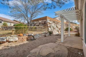 Fenced yard with a pergola and a patio