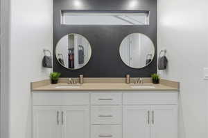 Bathroom with double vanity and a spacious closet